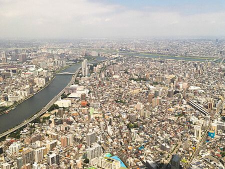Vista dall'alto di Tokyo con fiume ed edifici fitti.