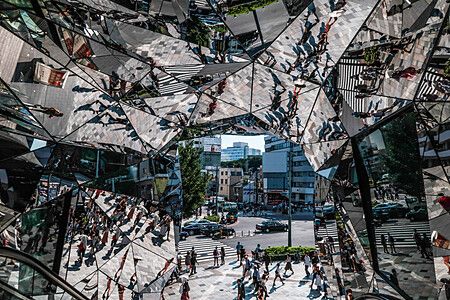 Ingresso a specchi del Tokyu Plaza con persone riflesse.