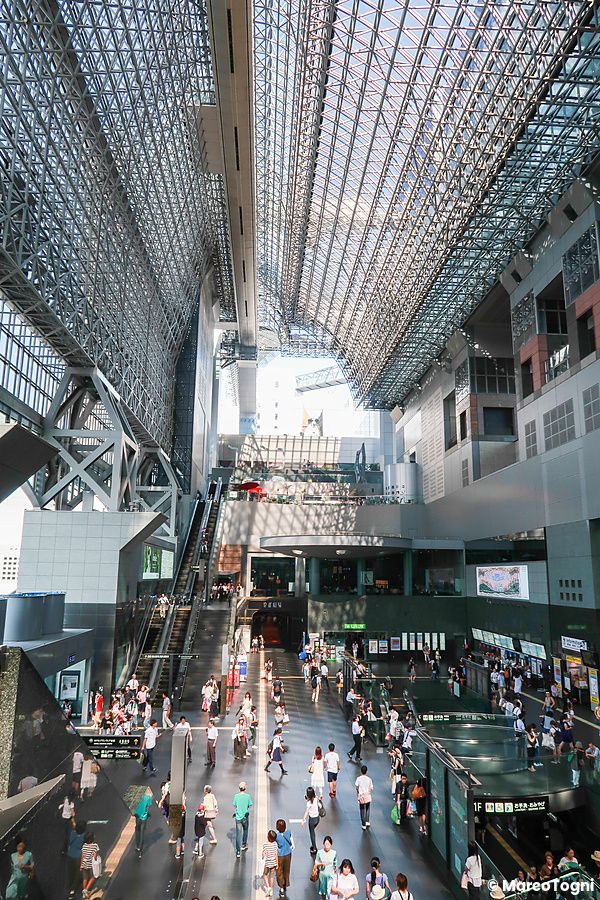 Vista interna dell'atrio principale della stazione di Kyoto con la sua imponente struttura in metallo e vetro.