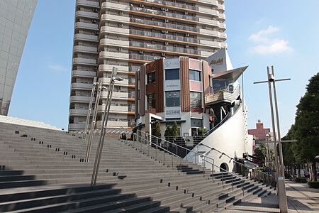 Asahi Beer Hall a Tokyo con scale e cielo azzurro.