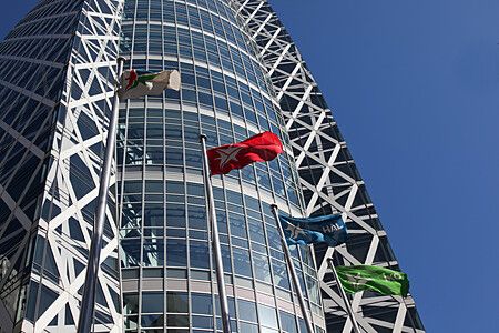 Cocoon Tower a Shinjuku con bandiere e cielo blu