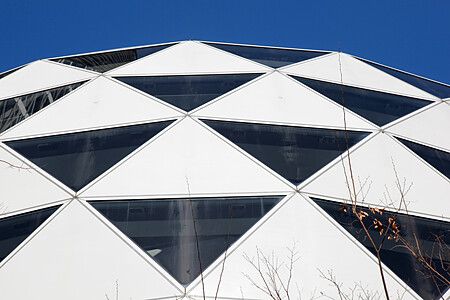 Dettaglio della facciata geometrica della Cocoon Tower a Shinjuku, Tokyo.