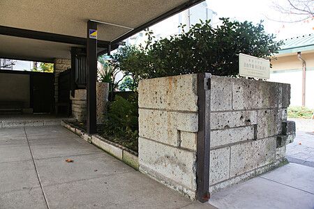 Angolo del cortile del Jiyugakuen Myonichikan con struttura in cemento e spazio verde.