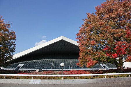 Edificio moderno con tetto triangolare e alberi autunnali al parco olimpico di komazawa.