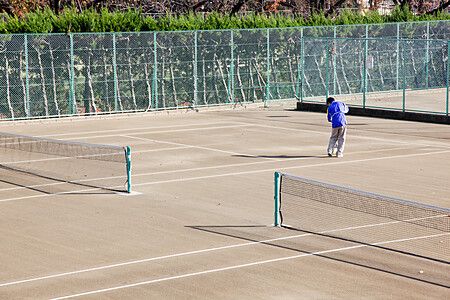 Persona su un campo da tennis vuoto a Komazawa Olympic Park, Tokyo.