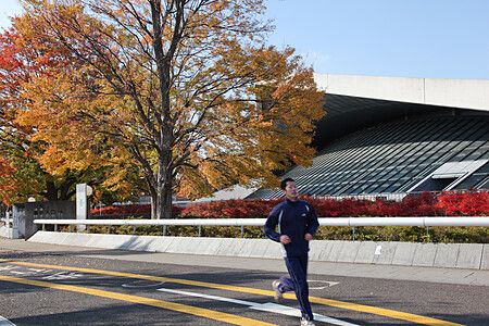 Uomo che corre in autunno nel Parco olimpico di Komazawa.