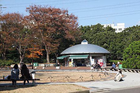 Parco olimpico di Komazawa con struttura circolare e persone in autunno.
