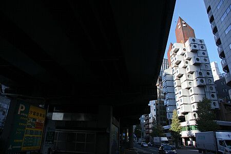 Nakagin Capsule Tower con edifici moderni a Tokyo e auto sulla strada