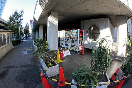Esterno della Nakagin Capsule Tower a Tokyo con distributori automatici.