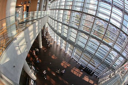 Interno del The National Art Center a Tokyo con ampie vetrate e persone.