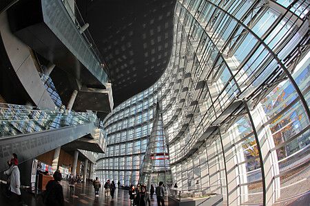Interno di The National Art Center a Tokyo con architettura moderna e persone presenti.