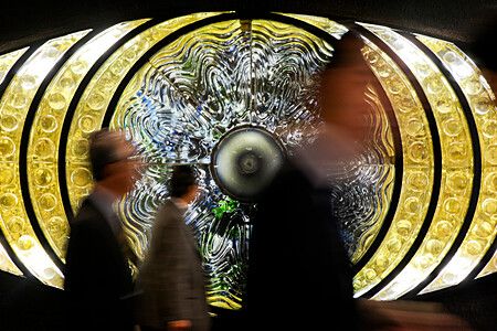 Scultura The Eye of Shinjuku con persone in movimento davanti.