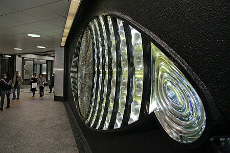 Scultura The Eye of Shinjuku nella stazione di Shinjuku con persone nel corridoio.