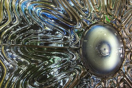 Scultura The Eye of Shinjuku con linee fluide e centro circolare.