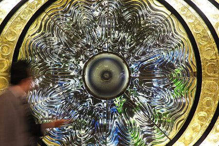 Scultura "The Eye of Shinjuku" alla stazione di Shinjuku con passante sfocato.