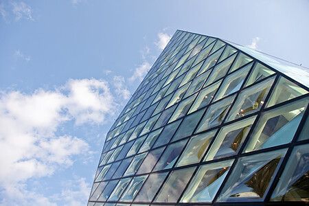 L'edificio Prada Aoyama a Tokyo sotto un cielo azzurro con nuvole bianche.
