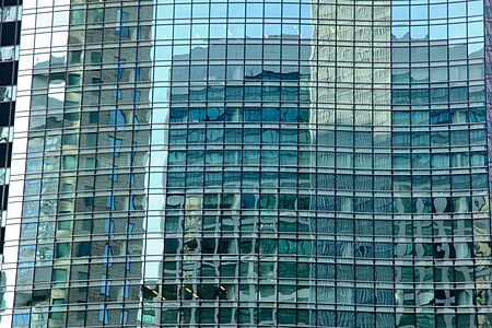 Riflessi di grattacieli su una facciata di vetro a Shiodome, Tokyo.