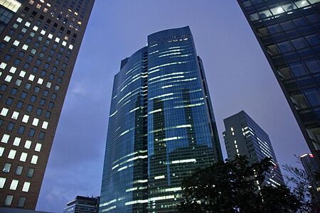 Grattacielo moderno a Shiodome al crepuscolo con luci accese.