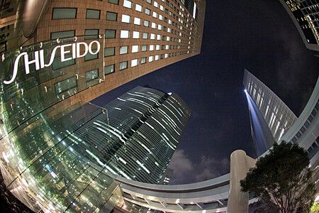 Edifici illuminati a Shiodome, Tokyo con il logo Shiseido visibile di notte.