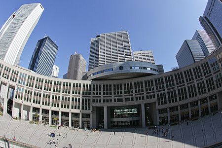 Il Palazzo del governo metropolitano di Tokyo con grattacieli e passanti.