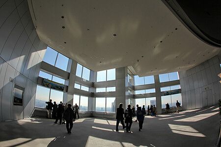 Interno del Tokyo Metropolitan Government Building con persone e vetrate panoramiche.