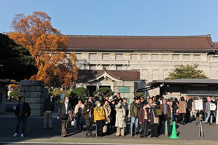 Persone camminano davanti al cancello di ingresso del Tokyo National Museum a Tokyo in una giornata soleggiata.