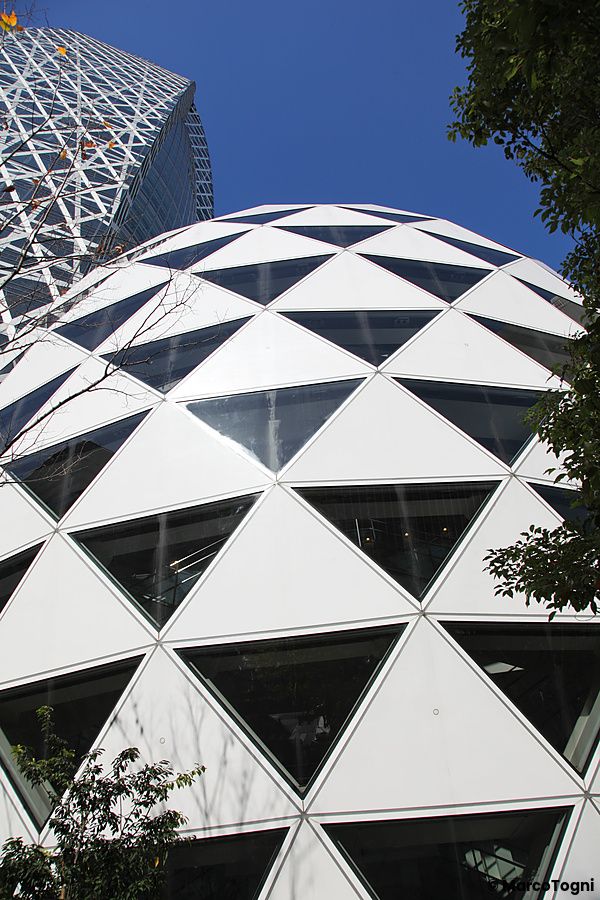 Parte superiore della Cocoon Tower a Shinjuku, Tokyo, con design a rete triangolare.