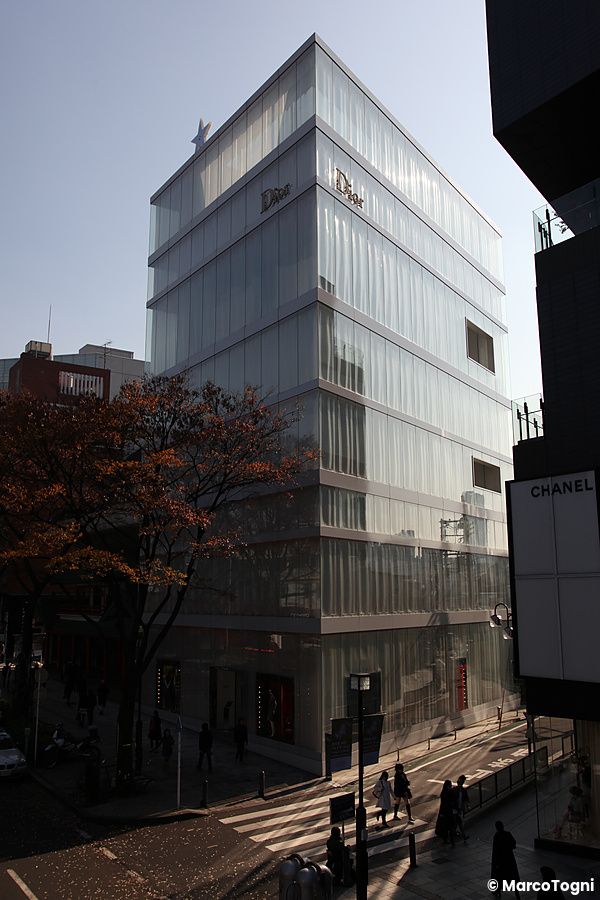 Edificio di vetro di Dior a Omotesando con persone in strada.
