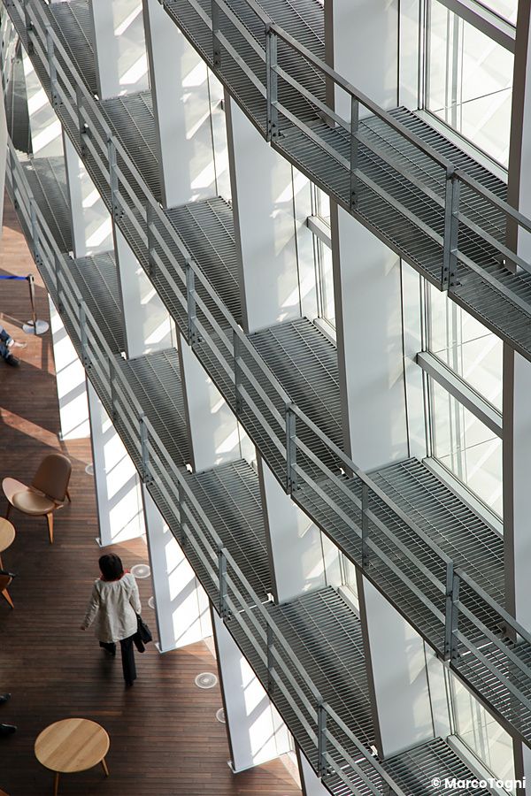 Interno di The National Art Center a Tokyo con passerelle e una persona che cammina.
