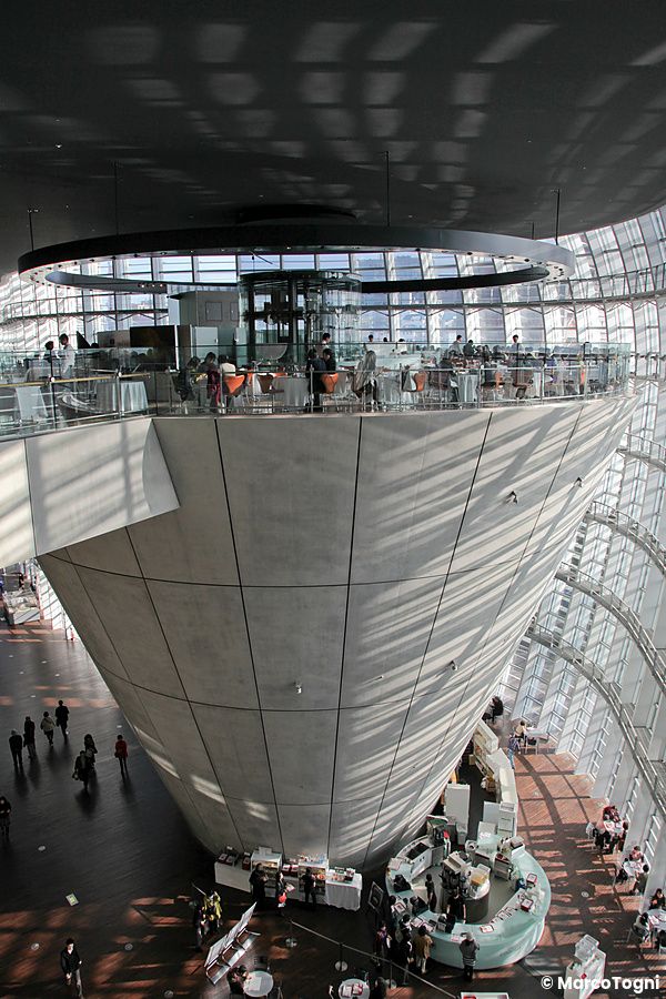 Interno di The National Art Center Tokyo con struttura conica e giochi di luce.