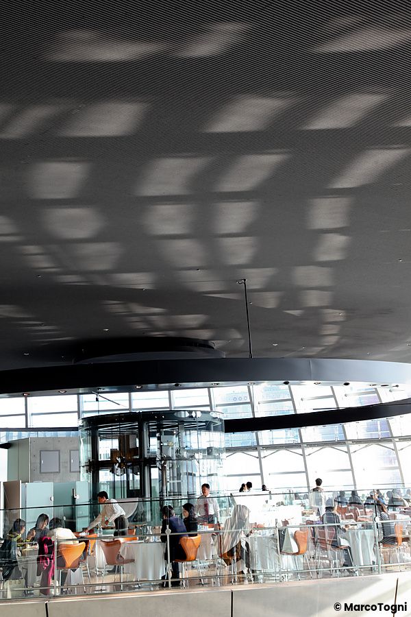 Interno del The National Art Center a Tokyo con persone sedute e ampie vetrate.