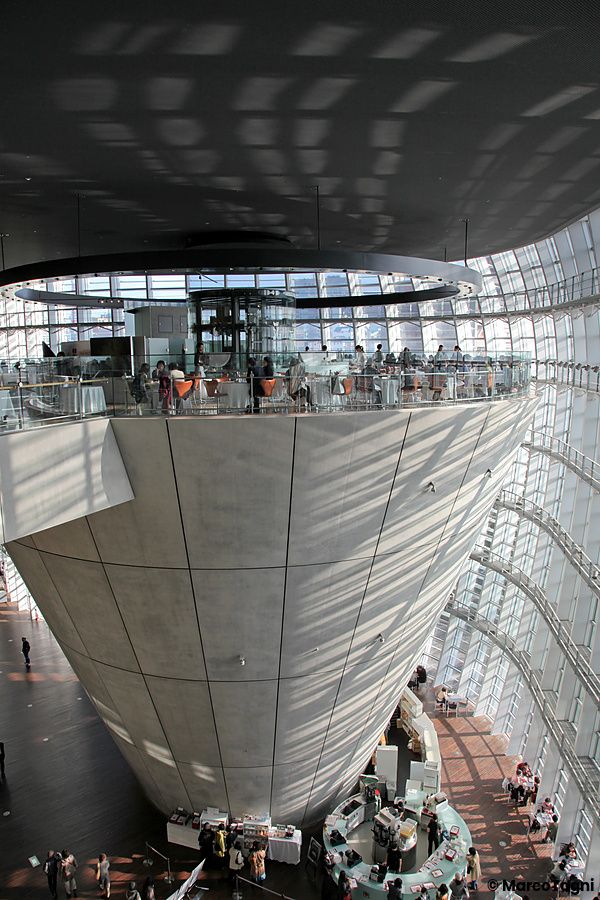 Atrio del The National Art Center a Tokyo con struttura a cono rovesciato e visitatori.