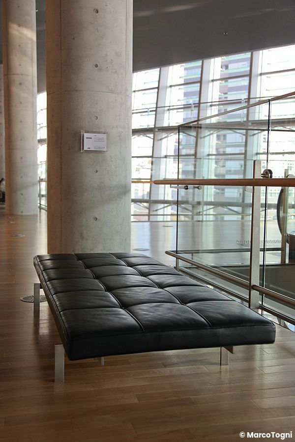 Interno moderno di The National Art Center a Tokyo con panca nera e grandi finestre.