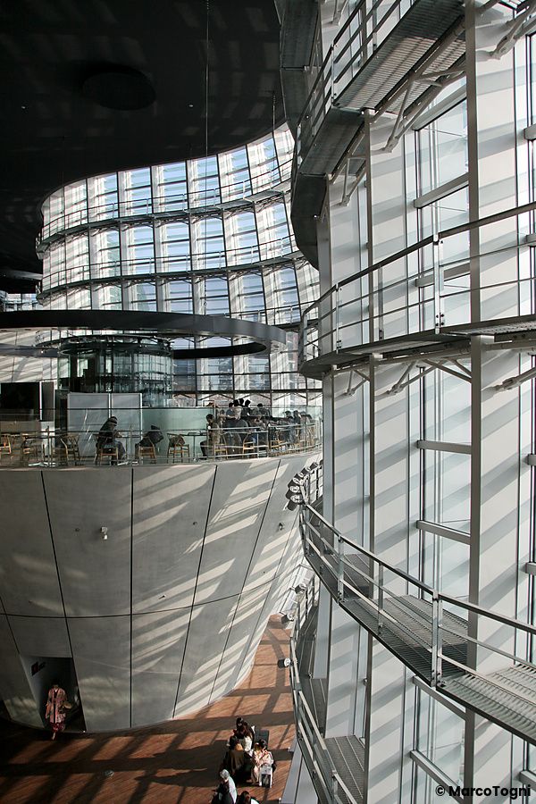 Interno di The National Art Center a Tokyo con strutture di vetro e visitatori.