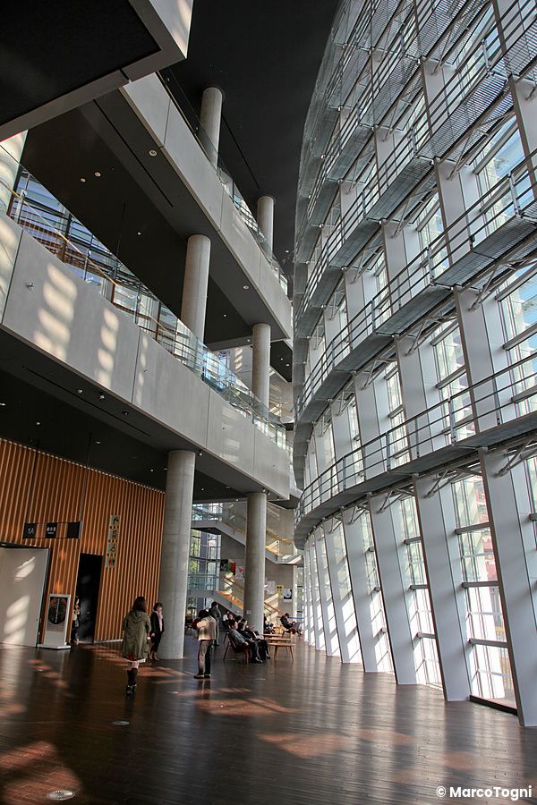 Interno del The National Art Center a Tokyo con pareti di vetro e passerelle