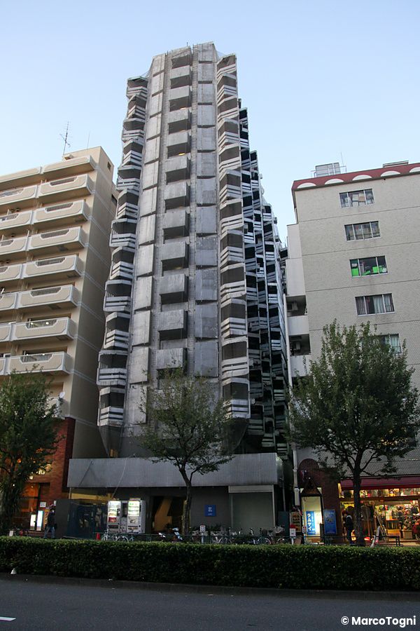 Edificio alto a più piani situato tra altri palazzi a Shinjuku.