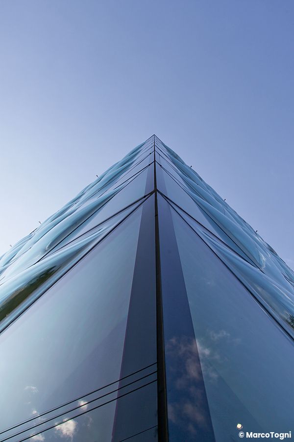 Edificio di vetro con riflessi sotto il cielo a Tokyo.