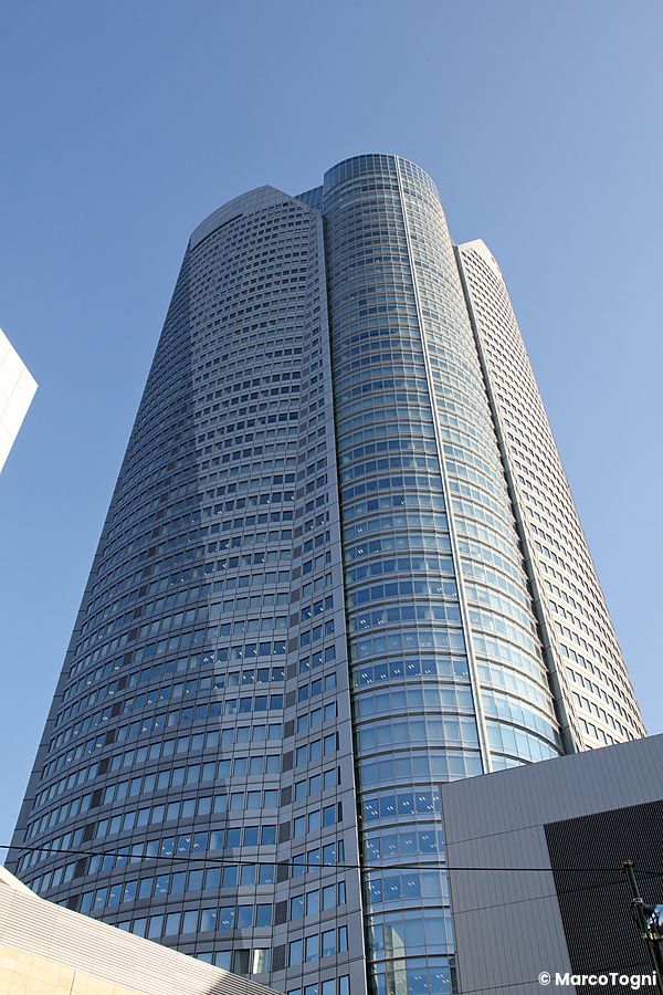 Grattacielo di Roppongi Hills a Tokyo sotto un cielo blu.