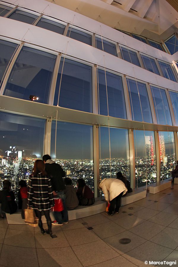 Persone osservano il panorama notturno di Tokyo da Roppongi Hills.