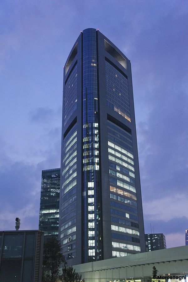 Grattacielo illuminato al crepuscolo a Shiodome, Tokyo.