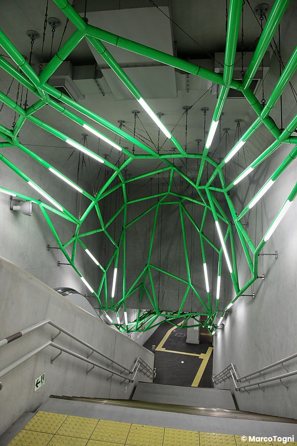 Scala con struttura in tubi verdi nella stazione di Iidabashi a Tokyo.