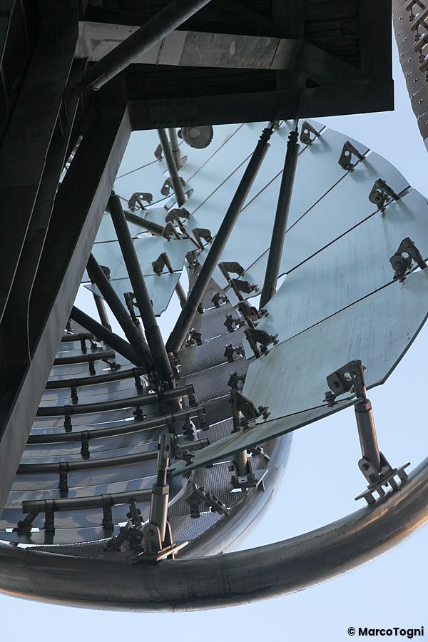 Struttura metallica a spirale con superfici trasparenti nella stazione di iidabashi a tokyo.