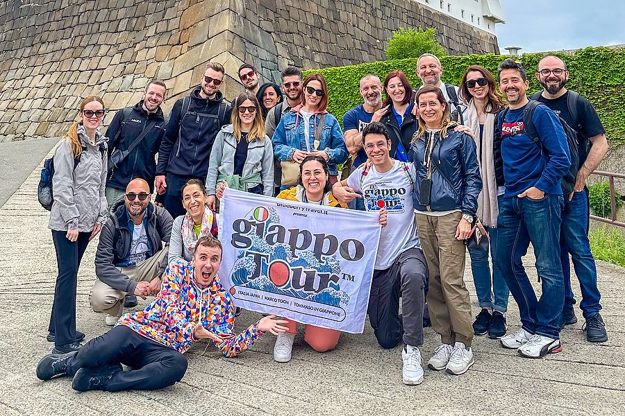 Gruppo di viaggiatori durante GiappoTour davanti alle mura del castello di Osaka.