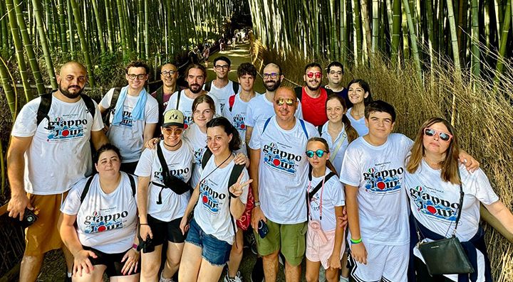 Un gruppo di viaggiatori con maglietta bianca con logo GiappoTour, alla foresta di bambù di Arashiyama.