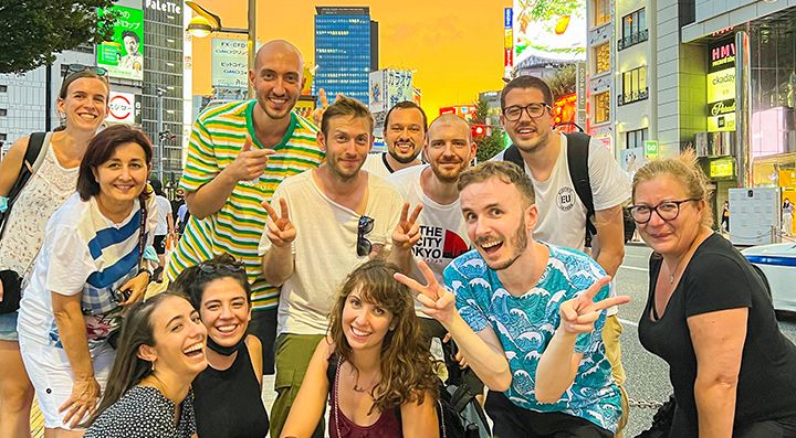Marco Togni insieme a un gruppo di viaggiatori al tramonto a Shinjuku.