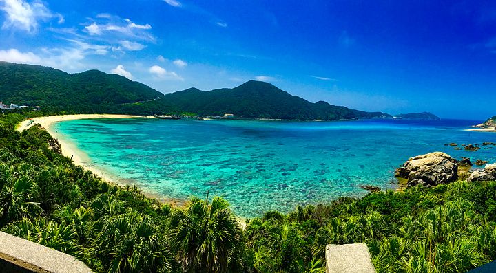 Vista panoramica della spiaggia Aharen a Tokashiki, Okinawa, con mare blu e sabbia bianca.