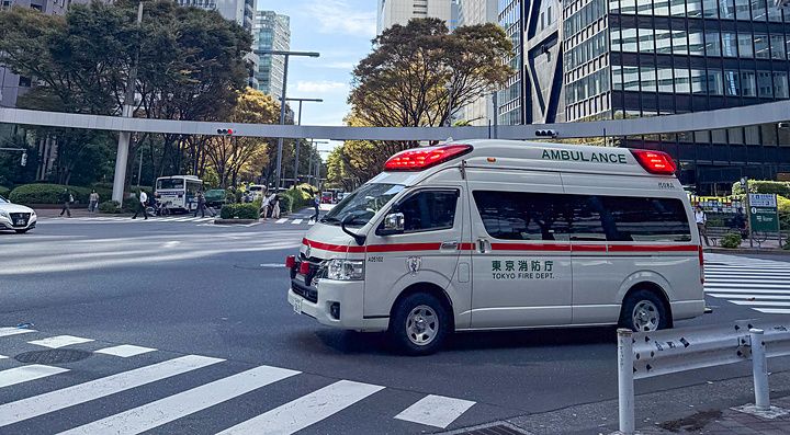 Ambulanza attraversa incrocio tra grattacieli a Shinjuku.