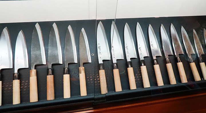Una vetrina di Aritsugu a Kyoto mostra una fila di coltelli artigianali giapponesi con manici in legno.