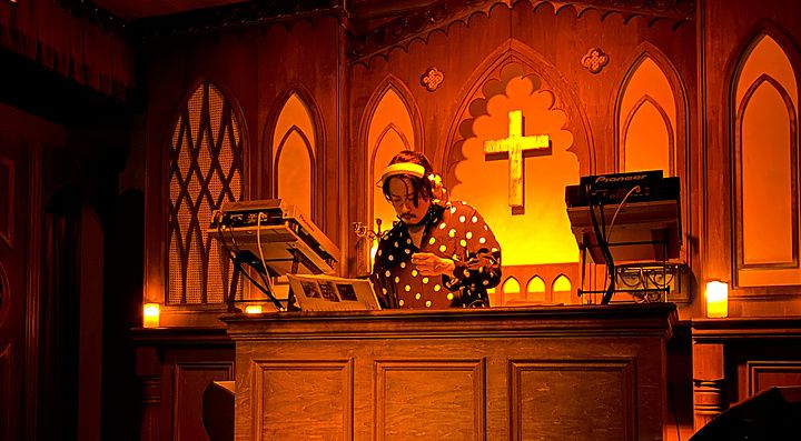 Una persona alla console da dj all'interno di The Church, bar a tema chiesa situato a Shibuya.