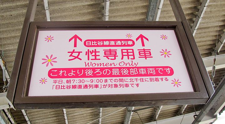 Un cartello rosa rettangolare in Giappone indica la carrozza riservata alle donne presso una stazione.